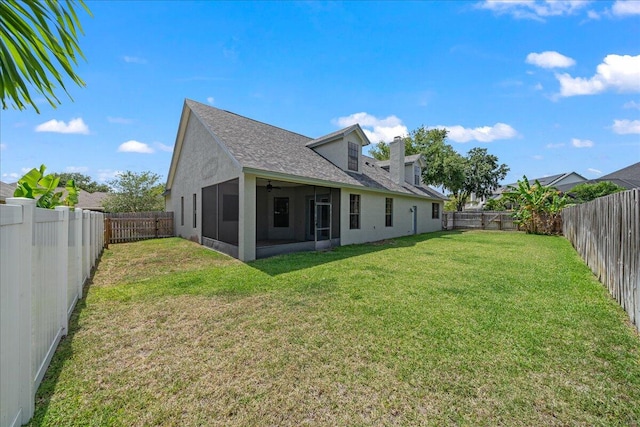 back of house with a sunroom and a yard