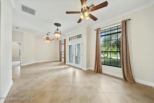 empty room with ornamental molding, light tile patterned floors, and french doors