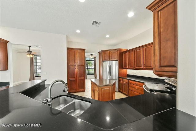 kitchen featuring light tile patterned flooring, sink, ceiling fan, appliances with stainless steel finishes, and a kitchen island