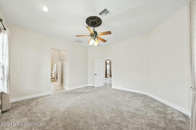 empty room featuring ceiling fan and light carpet