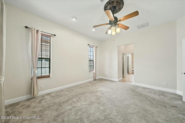 spare room with ceiling fan and light carpet