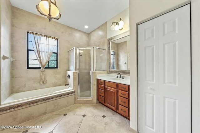 bathroom featuring plus walk in shower, vanity, and tile patterned flooring