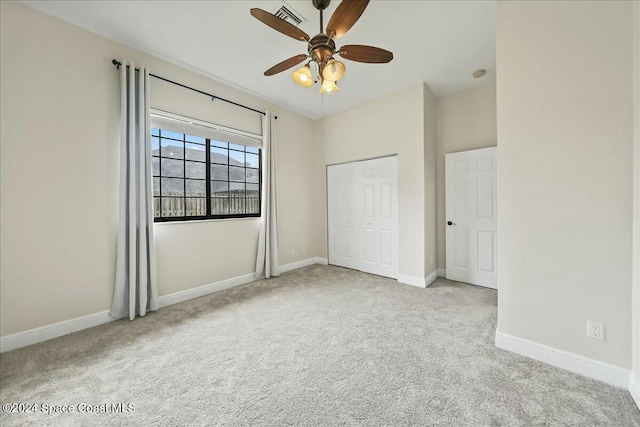 unfurnished bedroom featuring ceiling fan, light carpet, and a closet