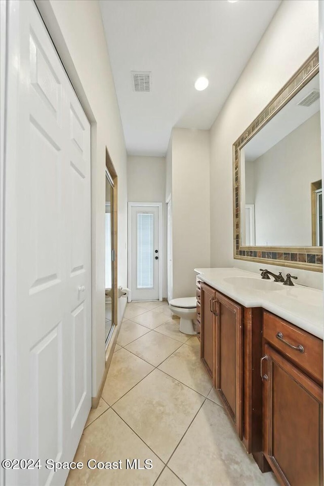 bathroom with toilet, vanity, tile patterned floors, and an enclosed shower