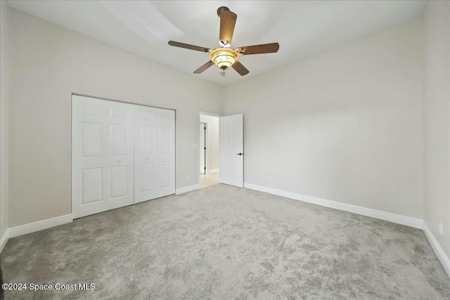 unfurnished bedroom featuring carpet, a closet, and ceiling fan