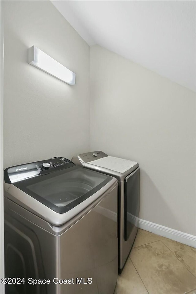 laundry room with washing machine and dryer and light tile patterned floors