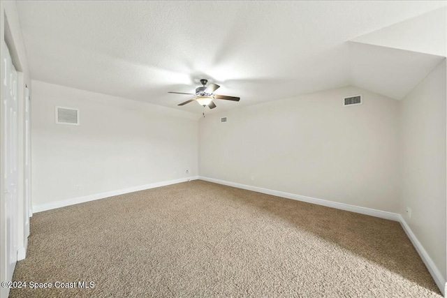 unfurnished room with a textured ceiling, ceiling fan, lofted ceiling, and carpet floors