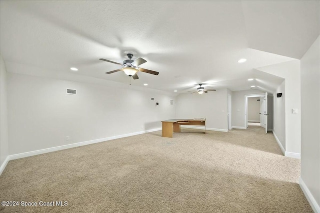 interior space featuring ceiling fan, light colored carpet, and a textured ceiling