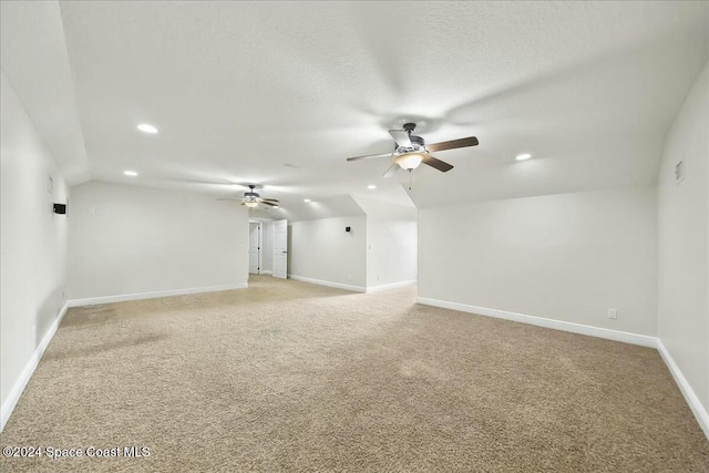 unfurnished room with ceiling fan, light carpet, and vaulted ceiling