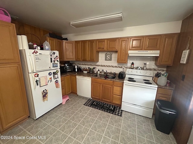 kitchen with decorative backsplash, white appliances, and sink