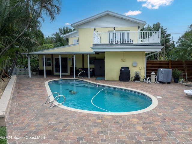 491 Indian Creek Dr, Cocoa Beach, FL 32931 - rear view of property with a balcony, stucco siding, a patio area, and a jacuzzi