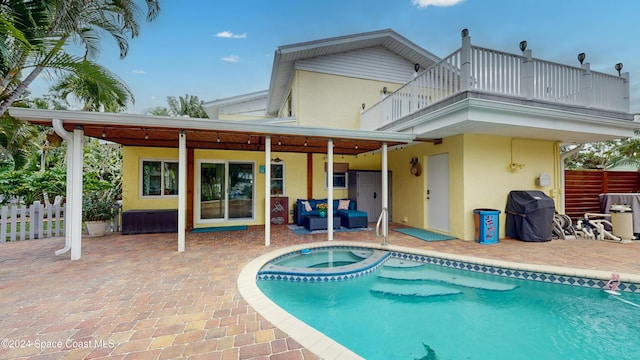 491 Indian Creek Dr, Cocoa Beach, FL 32931 - back of house featuring a balcony, a patio, stucco siding, outdoor lounge area, and a pool with connected hot tub