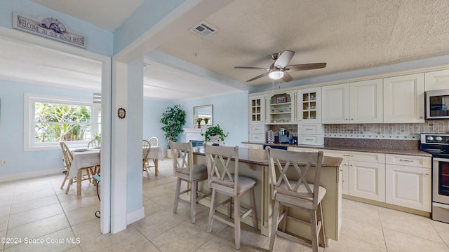 491 Indian Creek Dr, Cocoa Beach, FL 32931 - kitchen with appliances with stainless steel finishes, a kitchen breakfast bar, plenty of natural light, and backsplash