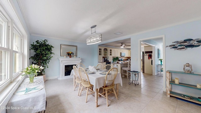491 Indian Creek Dr, Cocoa Beach, FL 32931 - dining room with crown molding, a glass covered fireplace, a ceiling fan, and light tile patterned floors