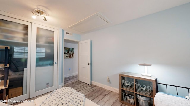 491 Indian Creek Dr, Cocoa Beach, FL 32931 - bedroom with attic access, wood finished floors, a closet, and baseboards