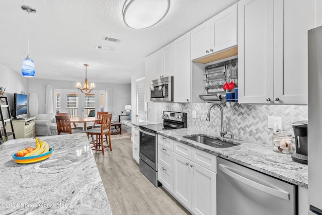 kitchen featuring white cabinets, light wood-type flooring, sink, and appliances with stainless steel finishes