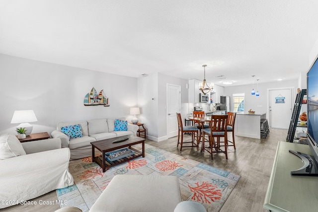 living room featuring light hardwood / wood-style floors and an inviting chandelier