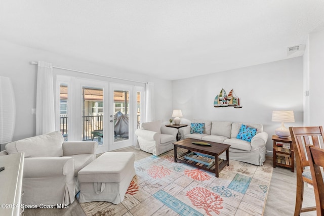 living room featuring french doors and light wood-type flooring