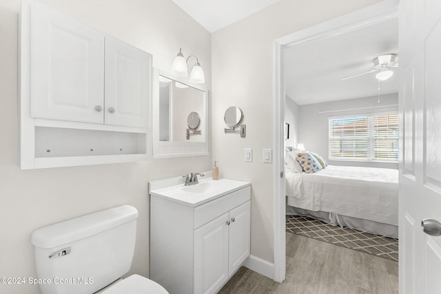 bathroom featuring vanity, hardwood / wood-style flooring, toilet, and ceiling fan