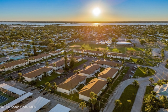 aerial view at dusk featuring a water view