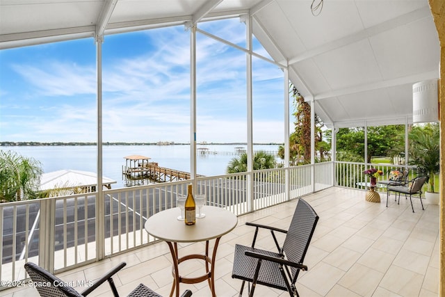 sunroom featuring a water view and vaulted ceiling