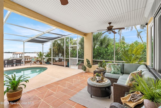 exterior space featuring an outdoor living space, a water view, ceiling fan, a lanai, and a patio area