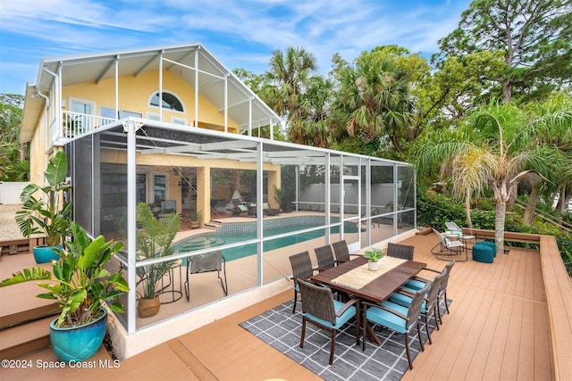 rear view of house with a swimming pool side deck, a patio area, and a lanai