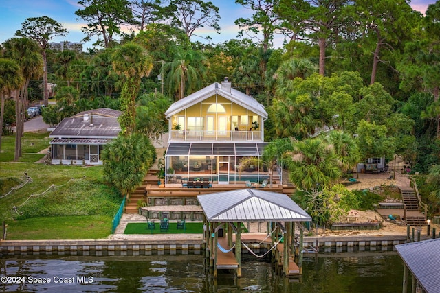 exterior space featuring a yard, a water view, a balcony, and a swimming pool