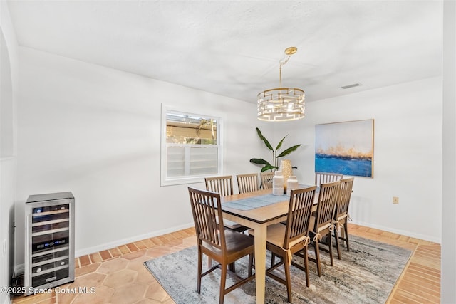 dining area featuring an inviting chandelier and beverage cooler