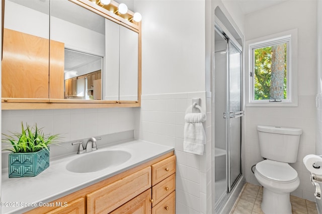 bathroom featuring vanity, tile patterned flooring, toilet, tile walls, and a shower with shower door