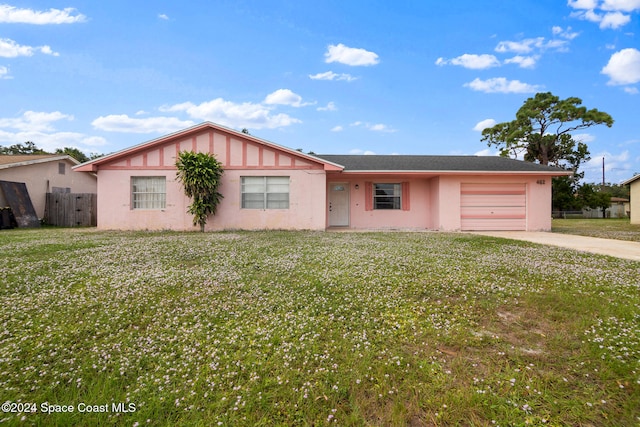 single story home featuring a garage and a front yard