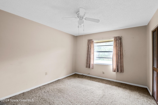 spare room featuring ceiling fan, carpet floors, and a textured ceiling