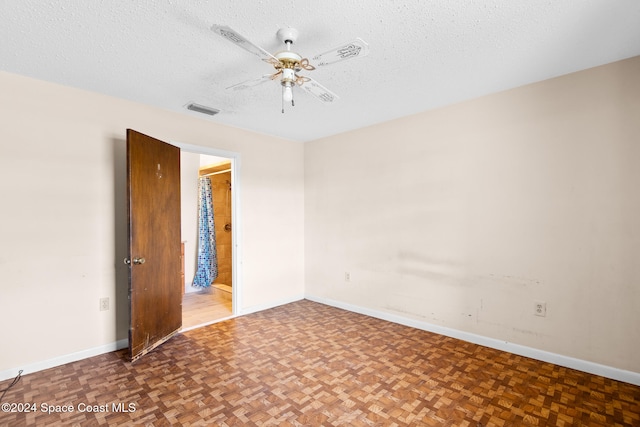 spare room with ceiling fan, parquet flooring, and a textured ceiling