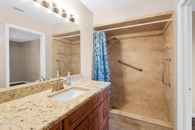 bathroom with wood-type flooring, vanity, and walk in shower