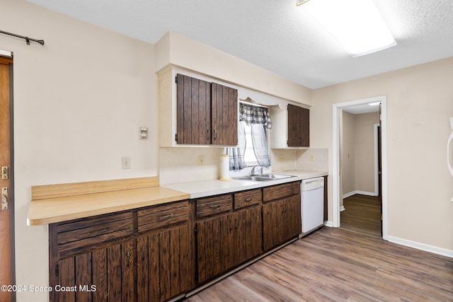 kitchen with sink, light hardwood / wood-style flooring, white dishwasher, a textured ceiling, and dark brown cabinets