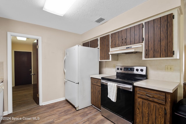 kitchen featuring stainless steel range with electric stovetop, dark brown cabinets, a textured ceiling, light hardwood / wood-style flooring, and white fridge