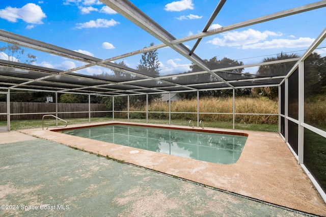 view of pool featuring glass enclosure and a patio area