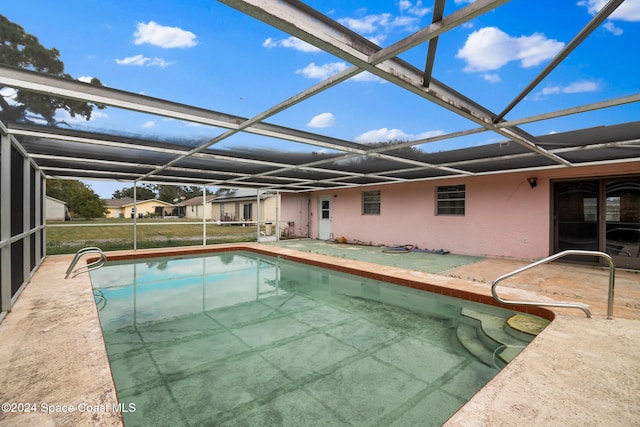 view of swimming pool with glass enclosure and a patio