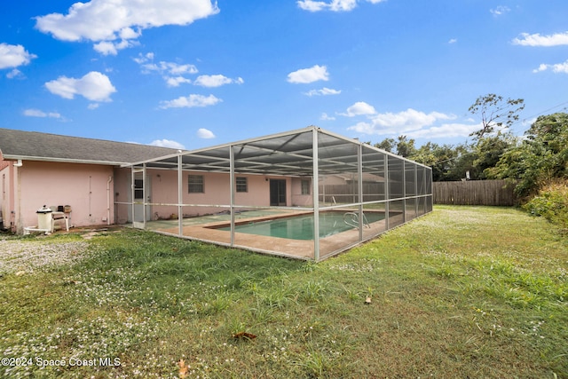 rear view of property with a yard, a fenced in pool, and glass enclosure