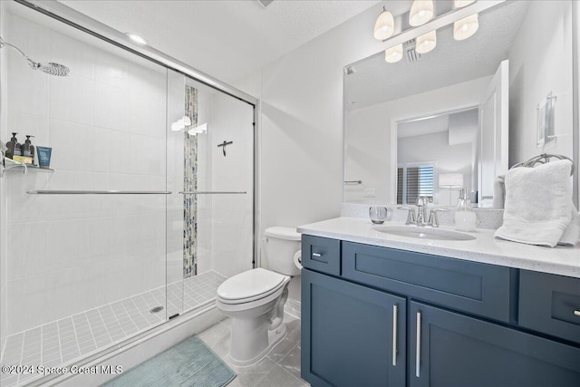 bathroom with vanity, toilet, a shower with door, and a textured ceiling