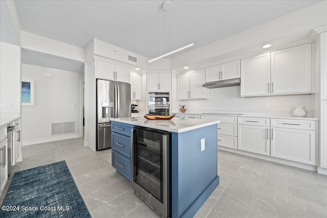 kitchen with stainless steel appliances, white cabinets, and beverage cooler