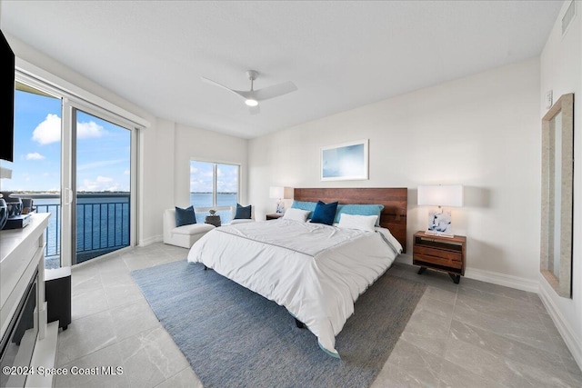 bedroom with access to outside, a water view, and ceiling fan