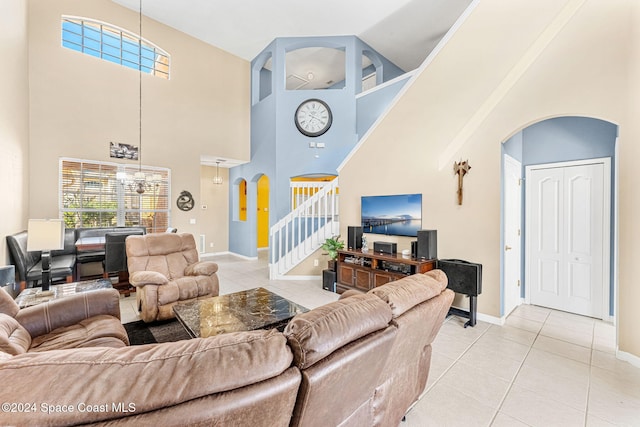 tiled living room with a notable chandelier and a high ceiling