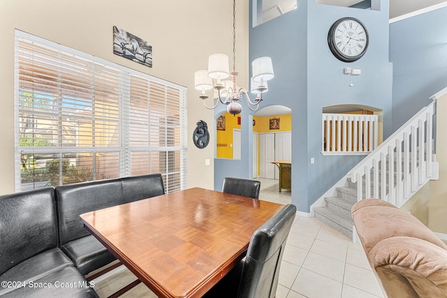 dining room featuring light tile patterned floors, a high ceiling, and a notable chandelier