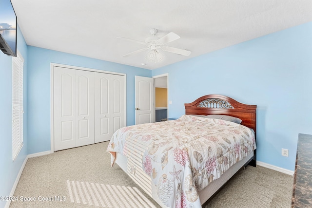 carpeted bedroom featuring ceiling fan and a closet