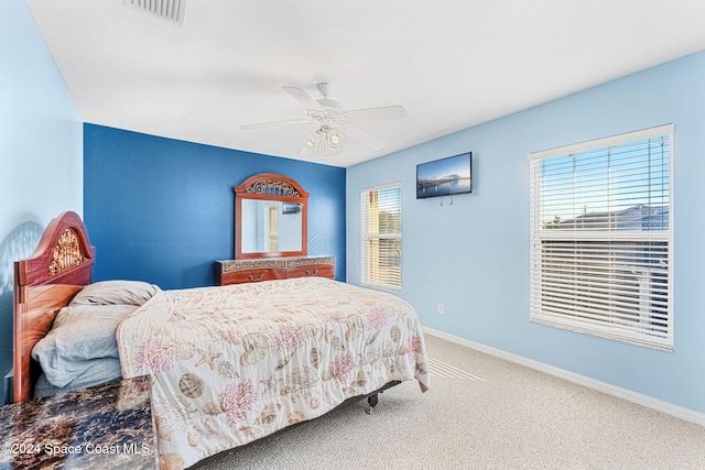 carpeted bedroom with ceiling fan and multiple windows