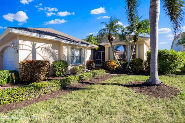 view of front of home with a front yard and a garage