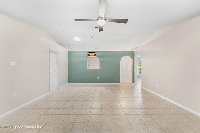 tiled empty room with ceiling fan and vaulted ceiling