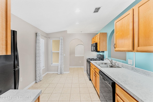 kitchen featuring sink, black appliances, lofted ceiling, and light tile patterned flooring