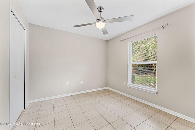 tiled spare room with ceiling fan